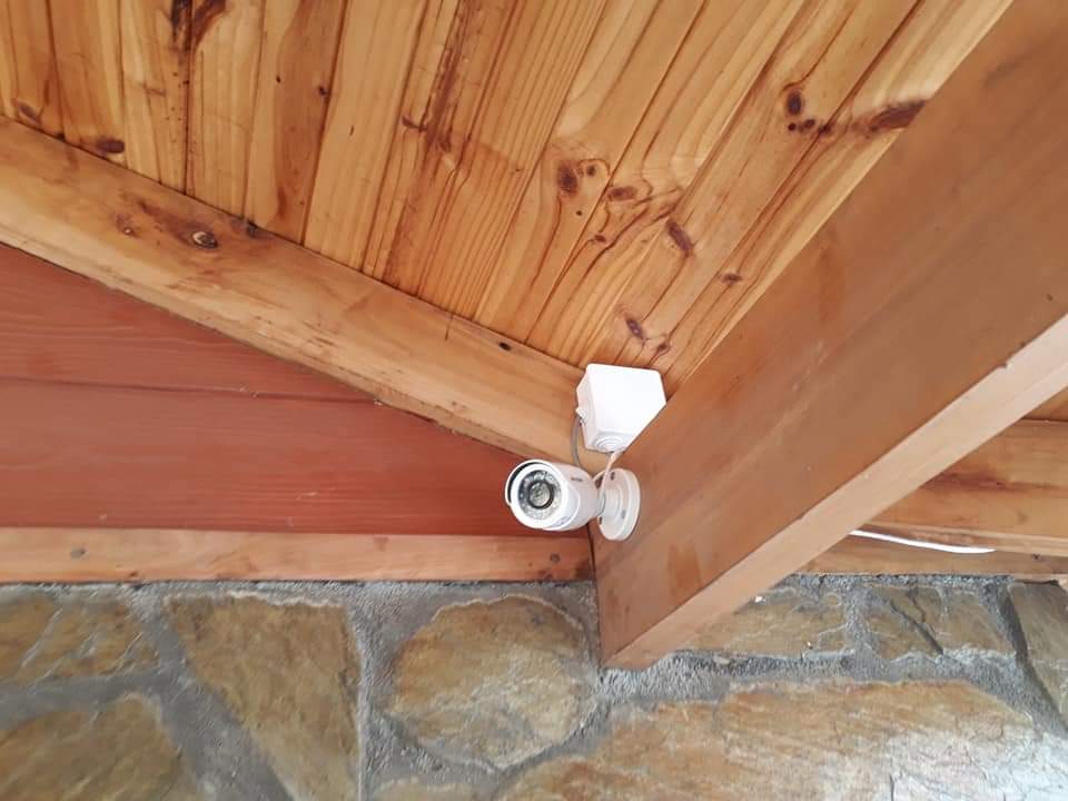 Cámara instalada bajo alero de madera